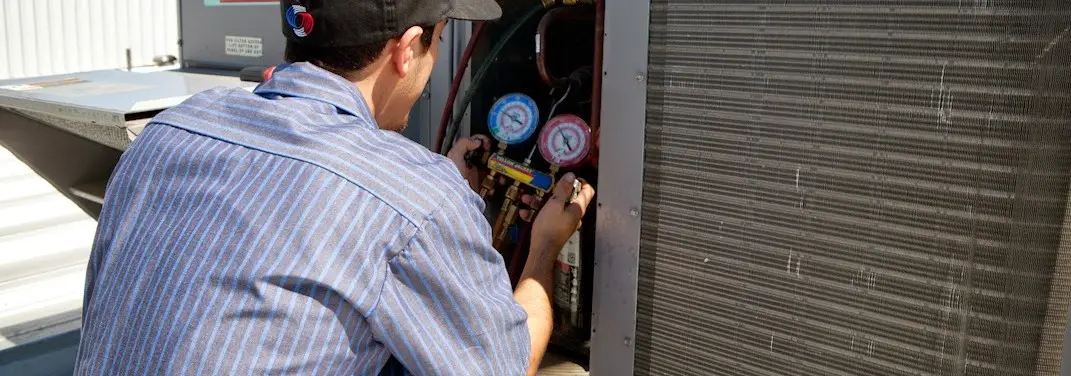 HVAC technician servicing a condenser unit in Wood-Ridge